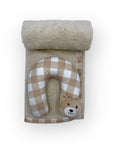 Baby neck pillow with checkered pattern and teddy bear face design, rolled up towel on a white background
