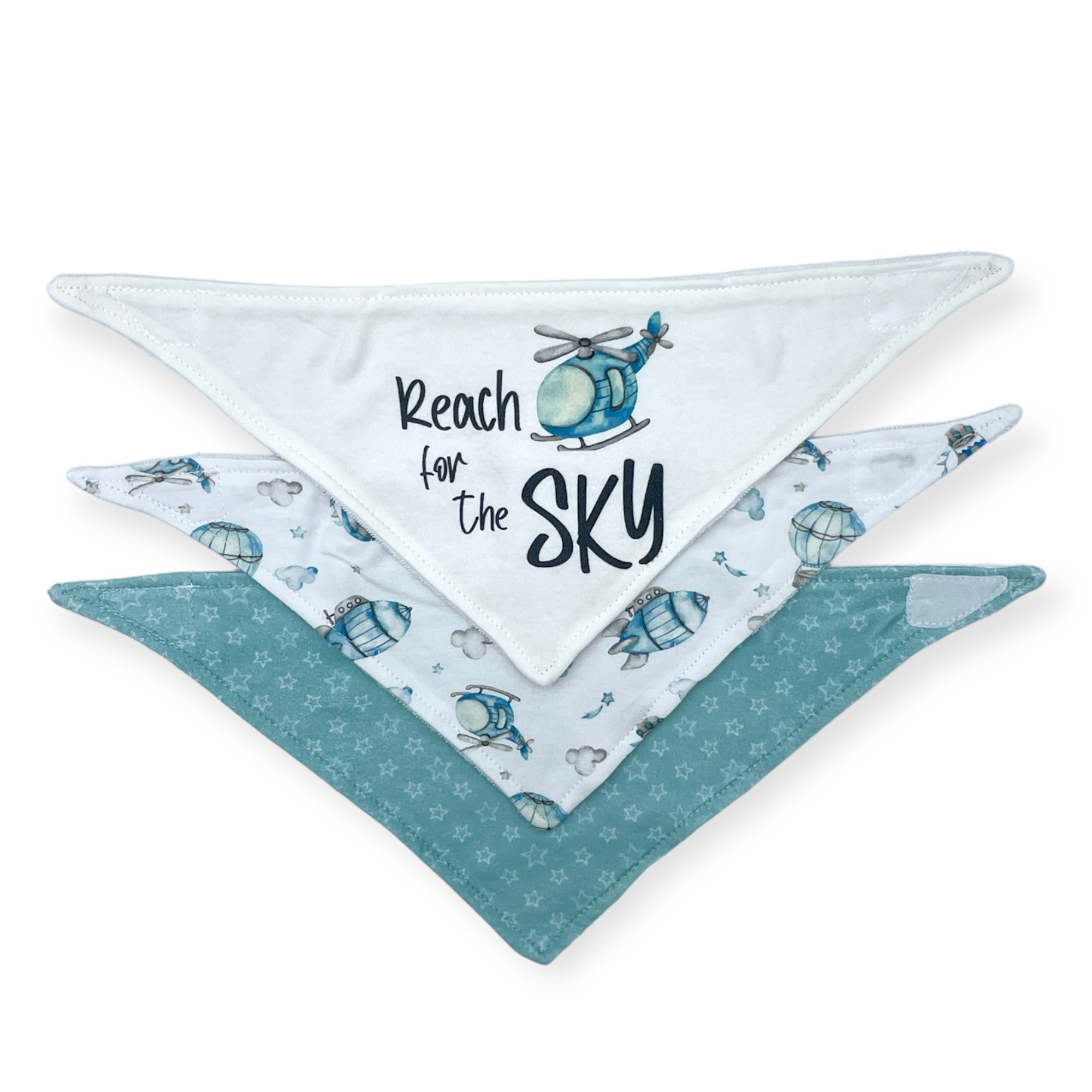 Two baby bibs with helicopter designs and 'Reach for the Sky' text on a white background