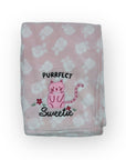 Pink blanket with cat design and text on a white background