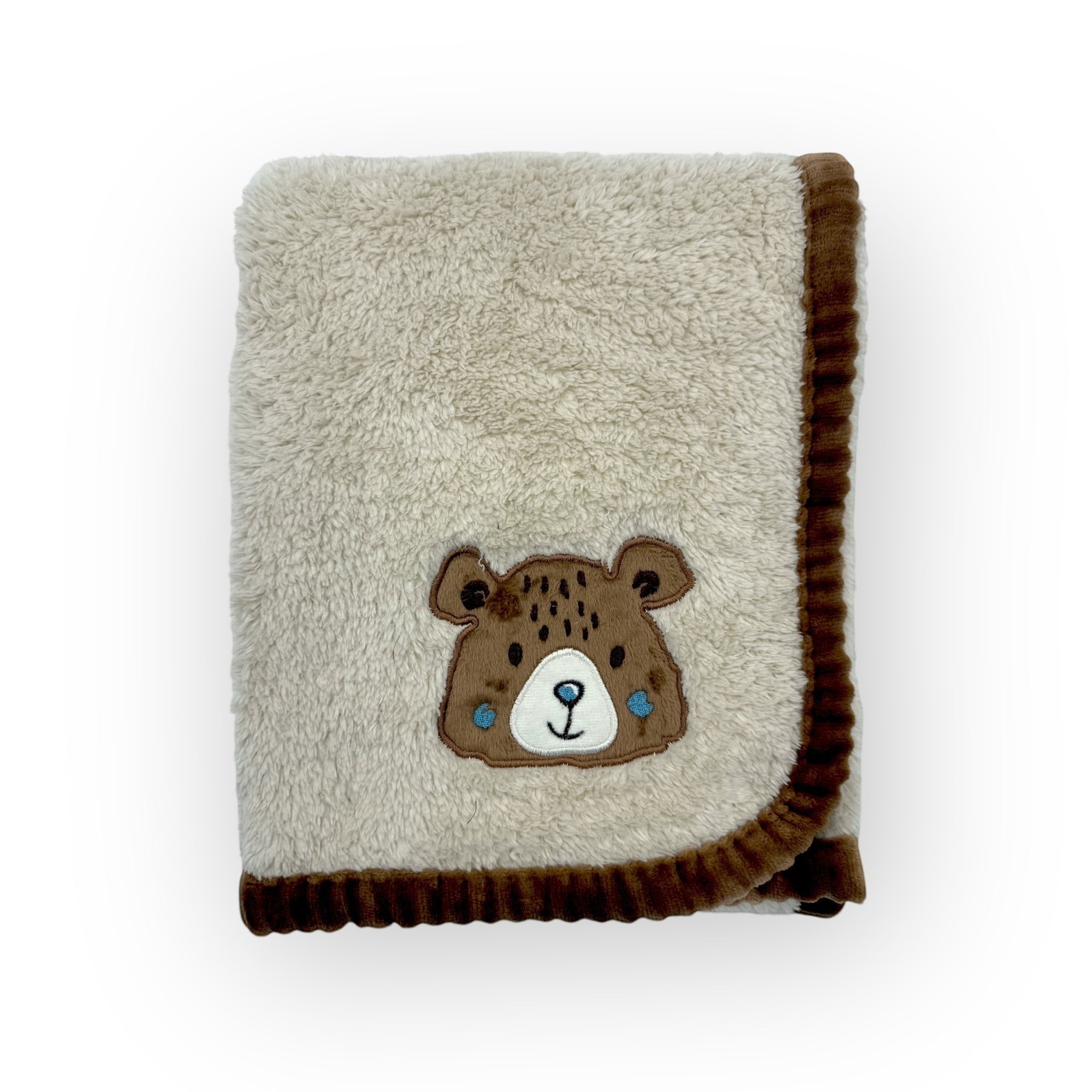 Folded blanket with a bear face patch on a white background