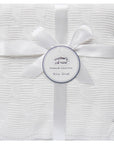 White baby shawl with a bow and 'Mother's Choice' label on a white background