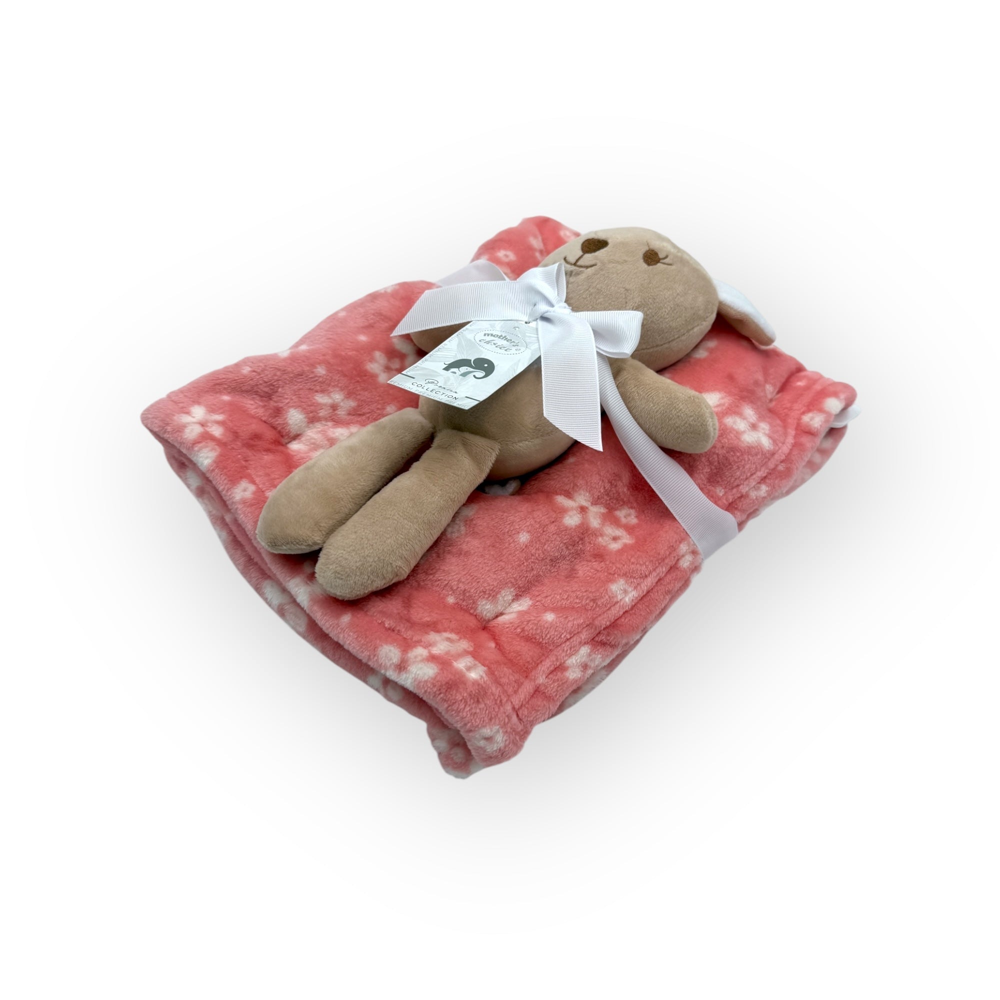 Stuffed animal toy on a pink floral blanket with a white ribbon on a white background