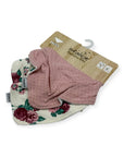 Two baby bibs, one floral and one pink with dots, on a white background.