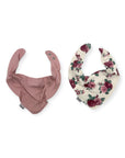 Two baby bibs, one pink with subtle pattern and one floral, on a white background.