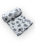 Two rolled-up baby blankets with black animal prints on a white background