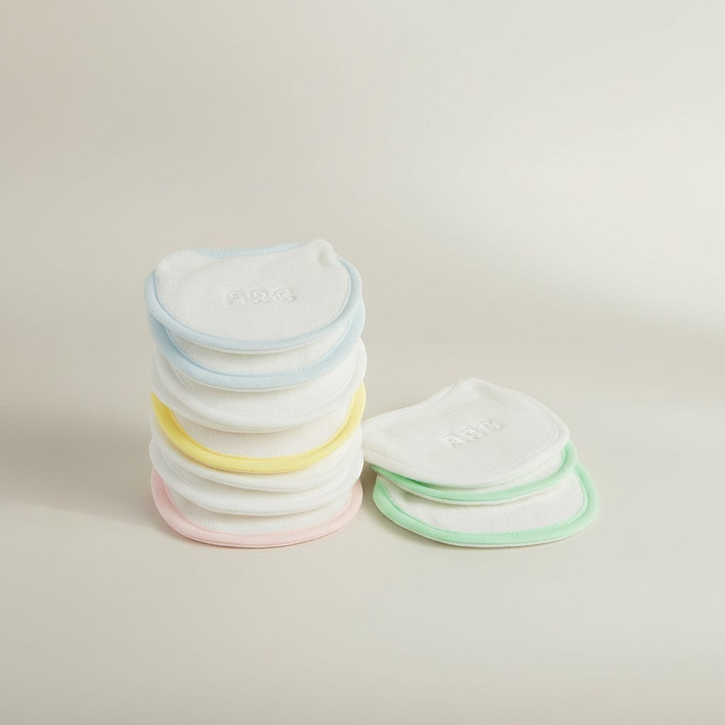 Stack of colorful baby bibs on a light background