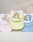 Three colorful baby bibs with cartoon designs on a neutral background