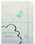 Baby shawl with ribbons and packaging details on a light gray background