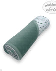 Folded green blanket with patterned edge on a white background, featuring 'Mother's Choice' branding.