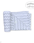 Gray and white chevron patterned blanket with a brand logo on a white background