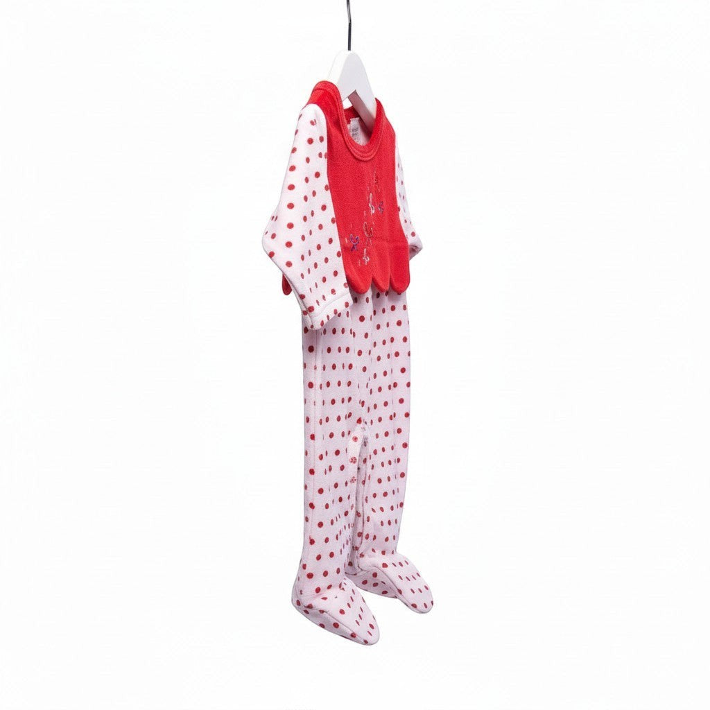 Baby outfit with red top and white pants with red polka dots hanging on a white background