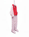 Baby outfit with red top and white pants with red polka dots hanging on a white background