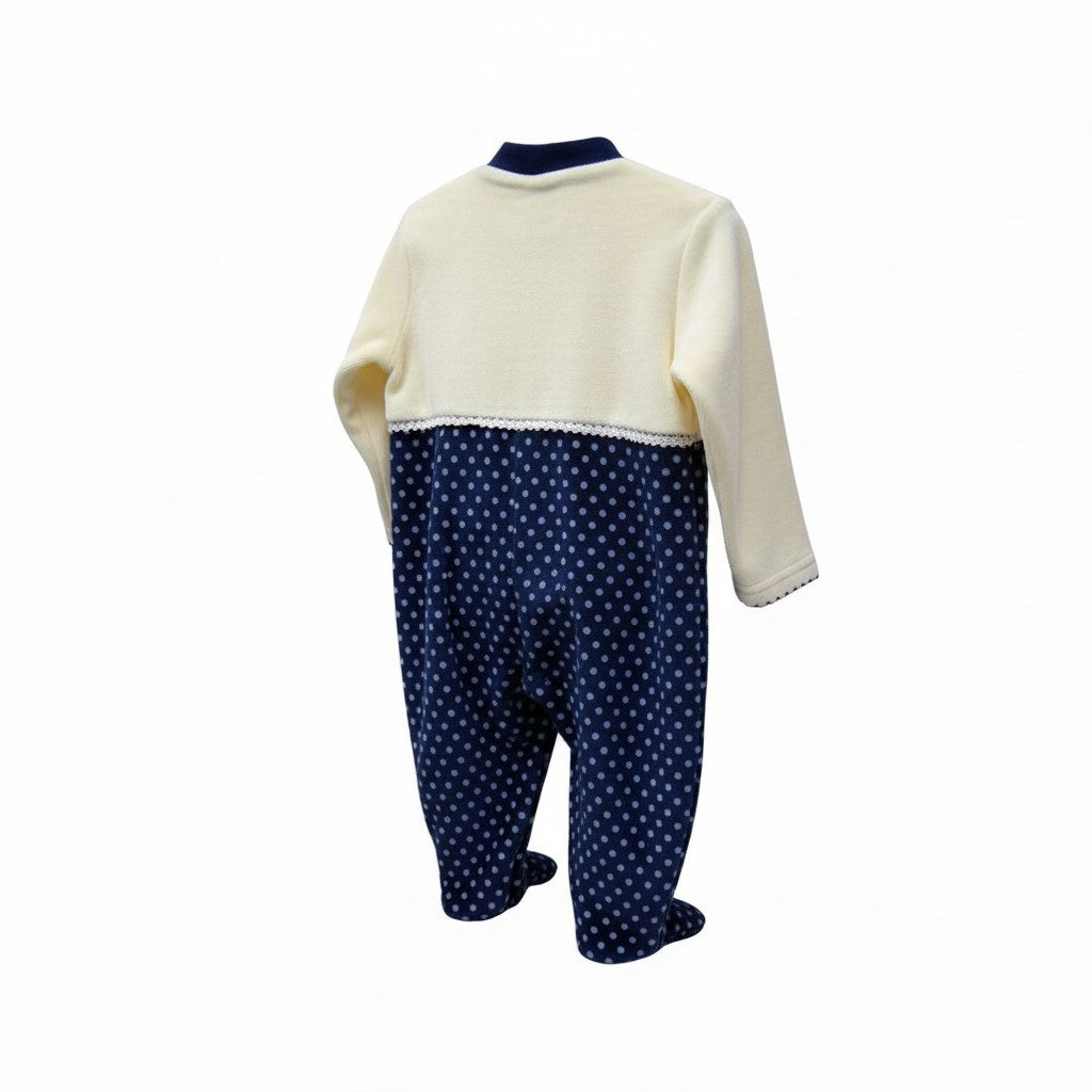 Baby outfit with cream top and navy polka dot pants on a white background