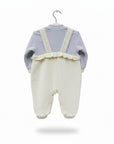 Baby outfit with light blue top and white pants on a hanger against a white background
