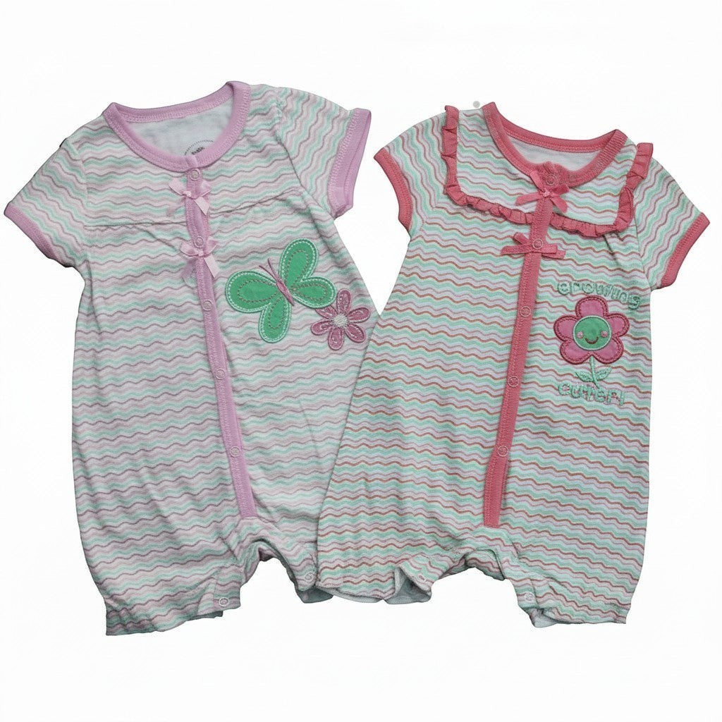 Two baby rompers with butterfly and flower designs on a white background