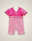 Pink and white striped baby romper with a matching top on a beige background