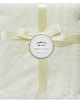 White baby blanket with a ribbon and 'mother's choice' label