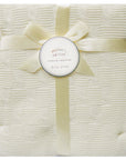 White textured blanket with a yellow ribbon and 'Mother's Choice' tag