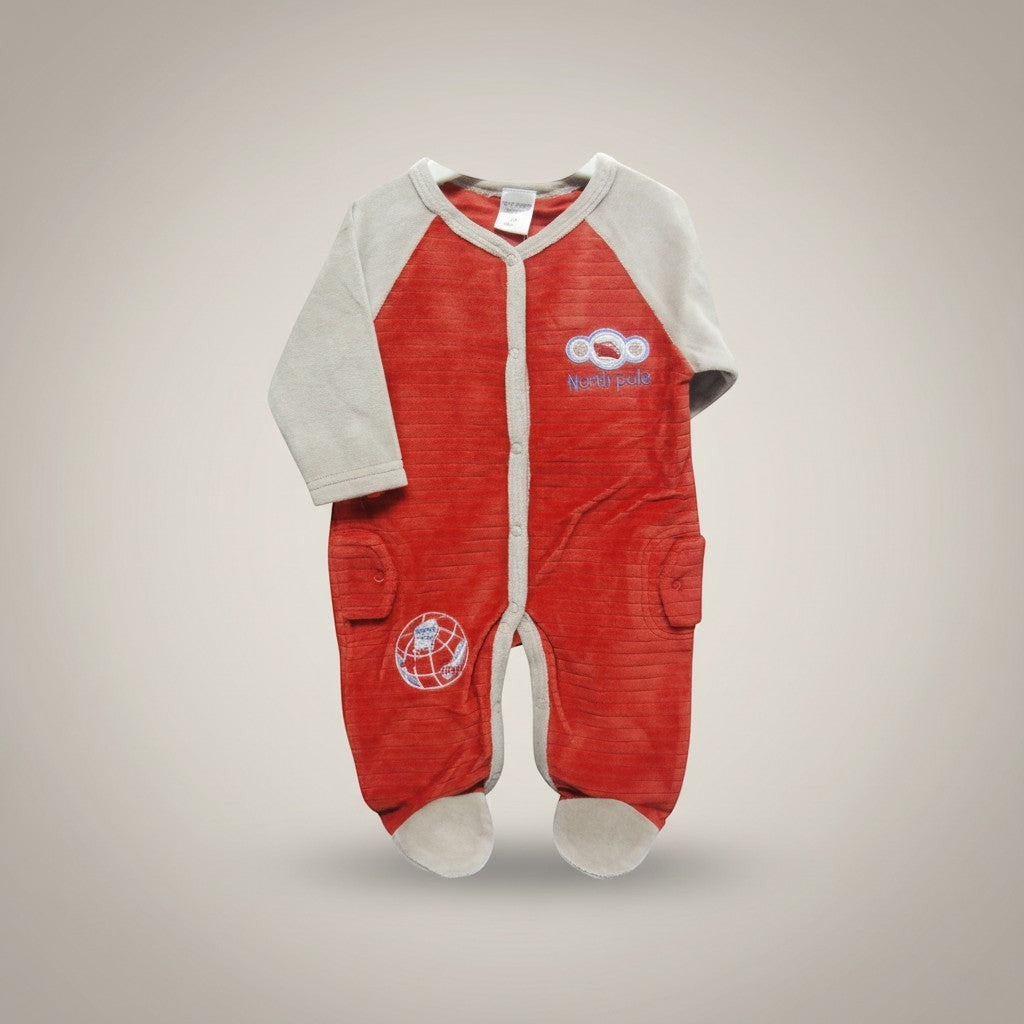 Red baby onesie with white accents on a beige background