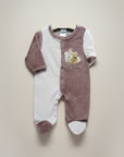 Baby onesie with teddy bear design on a beige background