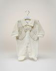 Baby outfit with jacket and pants on a hanger against a light background