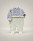 Baby outfit with light blue top and white pants on a gray background