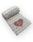Folded baby blanket with 'love you' text and heart design on a white background