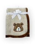 Fluffy blanket with a bear design and a white bow on a white background