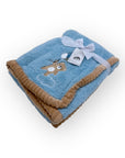 Blue baby blanket with brown trim and teddy bear design on a white background