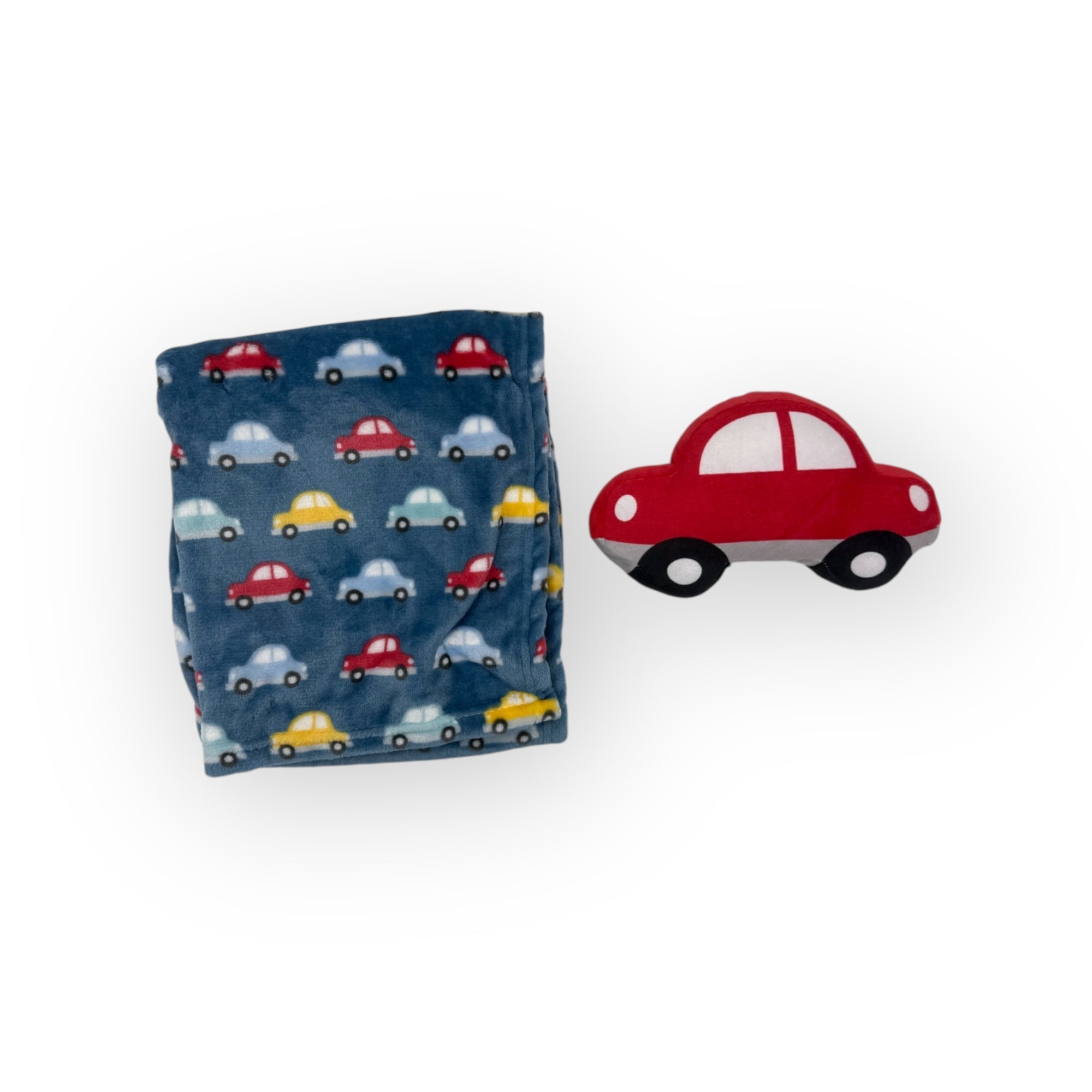 Folding towel with car pattern next to a red toy car on a white background