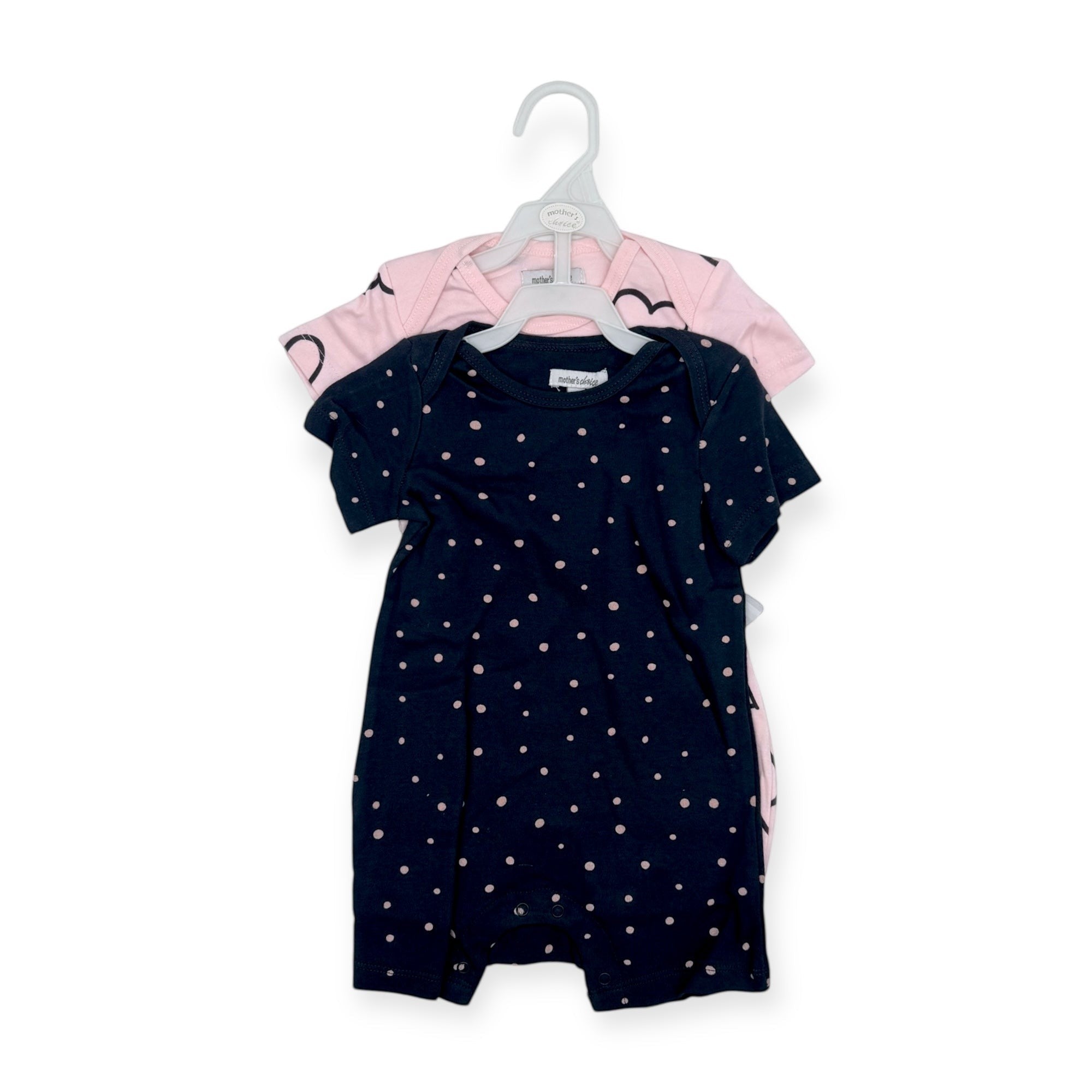 Navy baby romper with white polka dots on a hanger against a white background