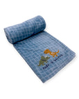 Rolled-up blue towel with dinosaur design and text on a white background