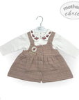 Baby outfit with brown quilted dress and white shirt on a hanger, branded 'Mother's Choice'.