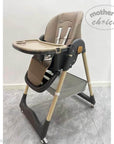 Baby high chair with tray on a gray floor, branded 'Mother's Choice'.