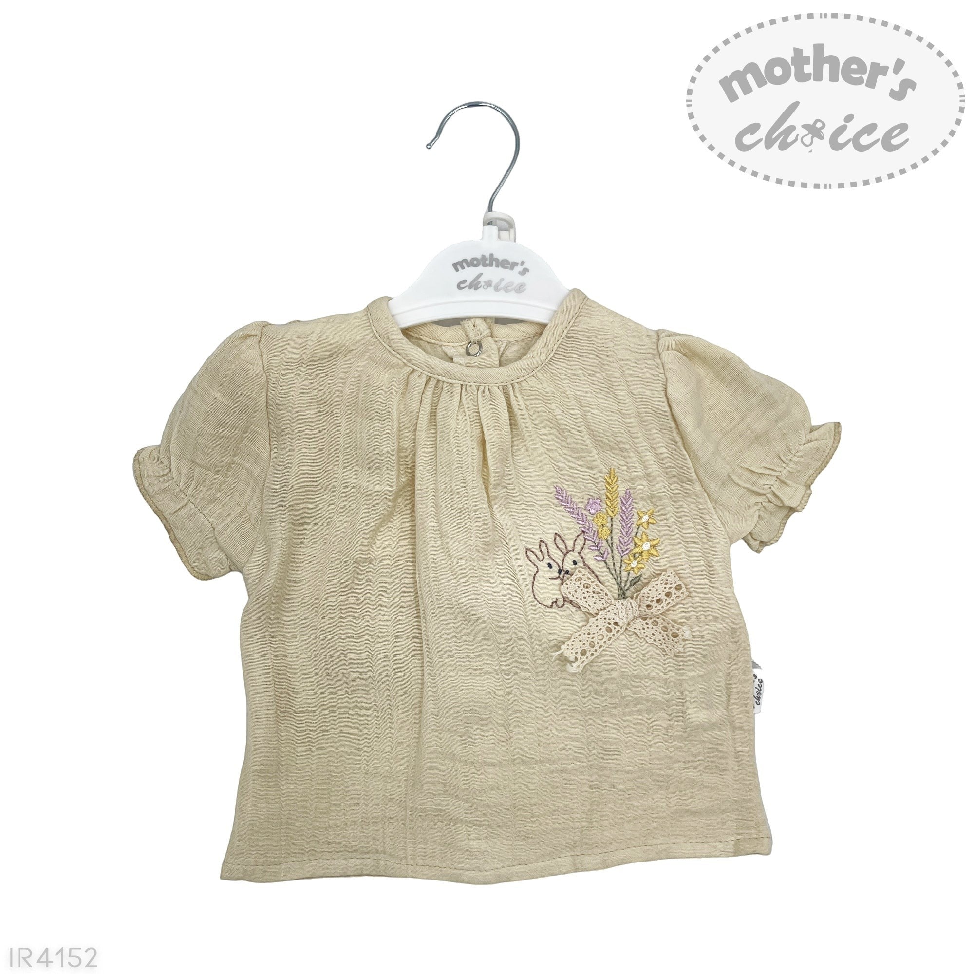 Beige baby blouse with floral design on a hanger against a white background