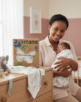 Woman holding a baby in a nursery with organic product packaging visible
