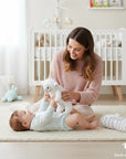 Stork And Baby Mothers Choice baby blanket and plush sheep toy set with a mother playing with her baby in a nursery