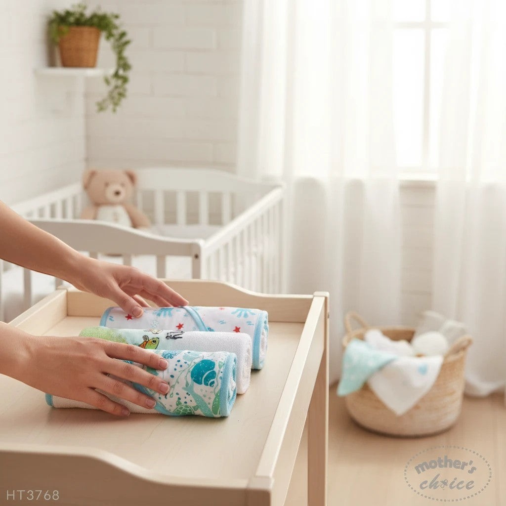Stork And Baby 3 pack of soft baby hooded towels with turtle and star prints on a wooden changing table