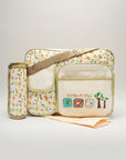 Stork And Baby beige diaper bag with a playful 'Little Friends' print featuring birds and trees. Includes a bottle holder.