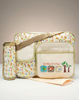 Stork And Baby beige diaper bag with a playful 'Little Friends' bird and tree print, featuring multiple pockets and a matching bottle holder.