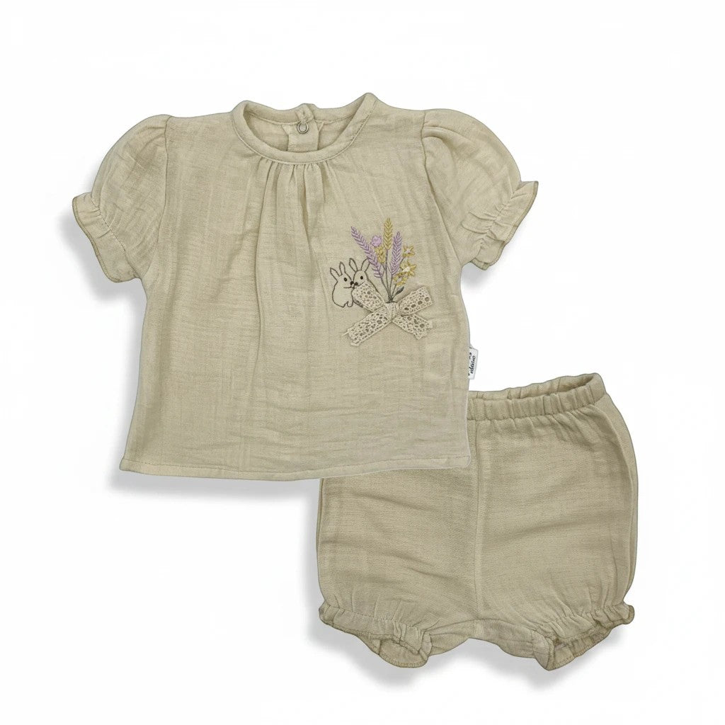 Stork And Baby beige muslin 2-piece set with embroidered bunnies and flowers on the top. Elastic waist shorts.