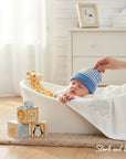 Stork And Baby blue and white striped knit baby hat on sleeping infant. Soft material.