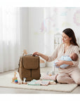 Stork And Baby brown PU upper baby bottle warmer, insulated for travel and outings. A mother holds her baby next to it.