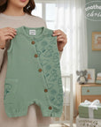 Stork And Baby sleeveless sage green muslin dungaree set with a dinosaur print and wooden buttons. Perfect for summer.
