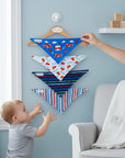 Stork And Baby 4 pack bandana bibs in blue with fire engines, white with helmets, navy with stripes, and red/blue chevron patterns.