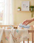 Stork And Baby cream knit baby blanket with giraffe and balloon embroidery. A bee sits on the blanket.