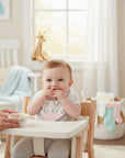 Stork And Baby girls' white bandana bib with pink teether and antler print, 2-pack.