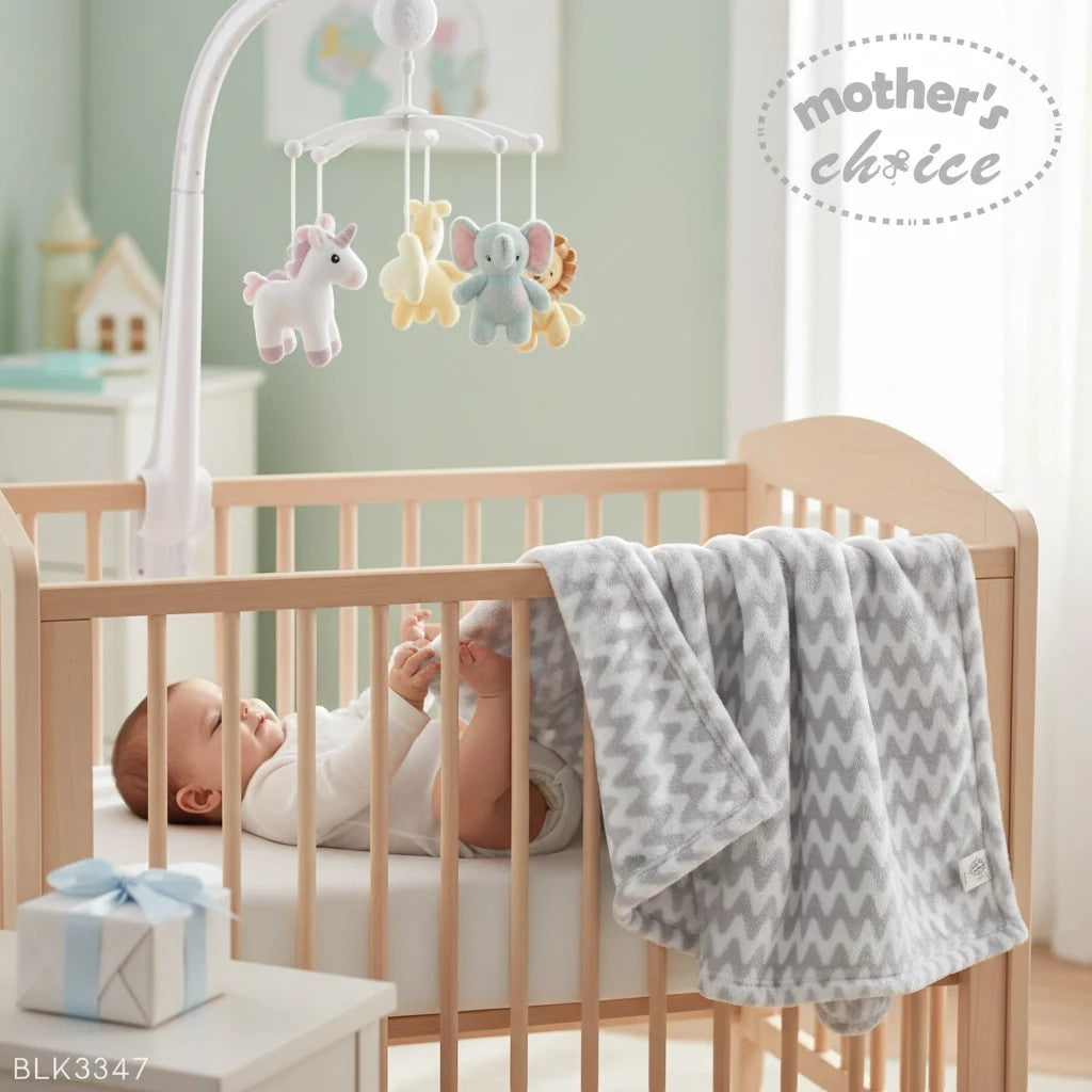 Stork And Baby Mothers Choice grey chevron coral fleece baby blanket with a nursery mobile in a wooden crib