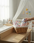 Stork And Baby 3 pack of Mothers Choice hooded baby towels with whale and sea creature prints in a woven basket