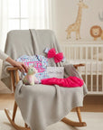 Stork and Baby pink and blue "Love" 3-piece infant set with unicorn plush, tutu, and headband on a chair.